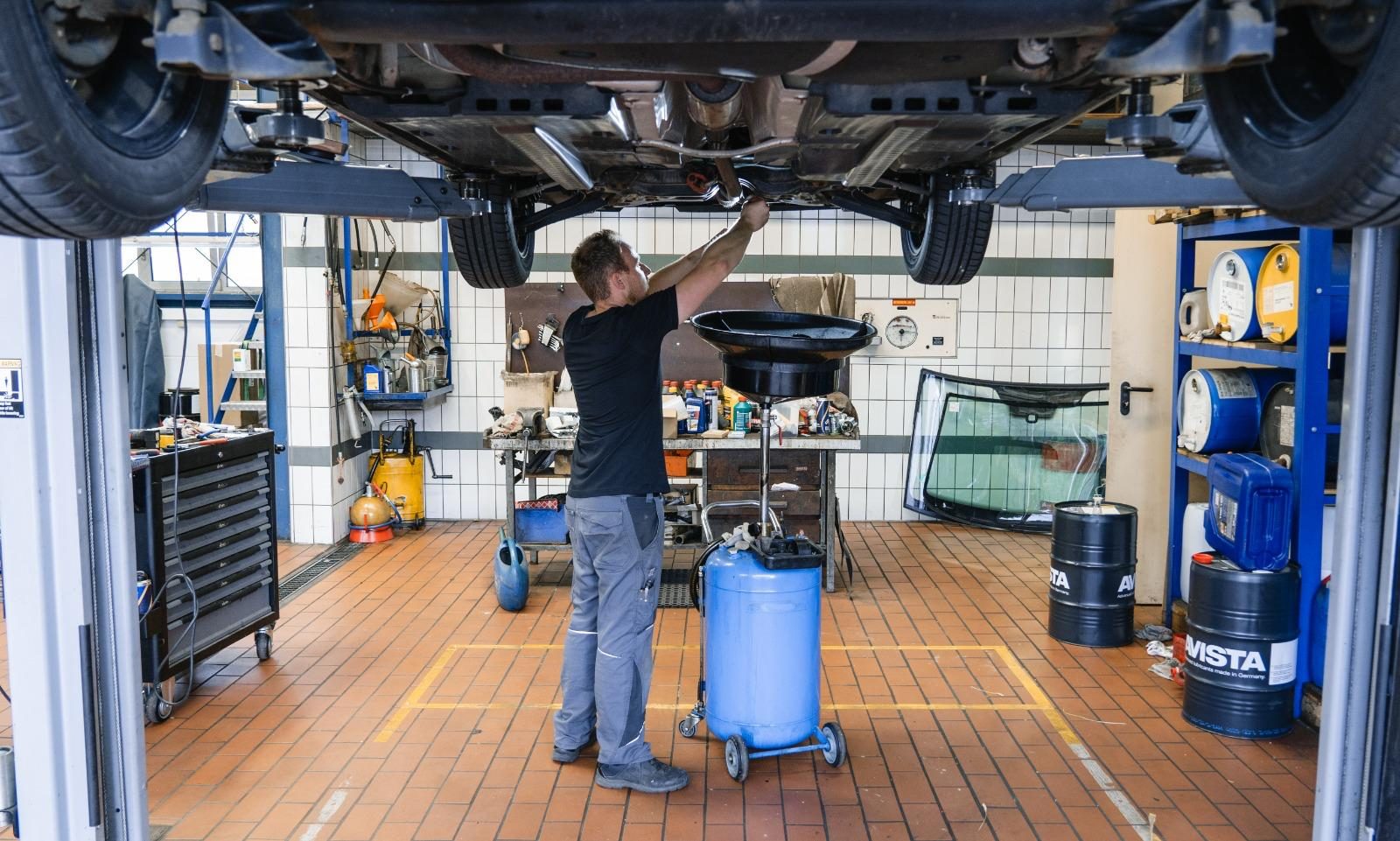 Mechaniker arbeitet in der Werkstatt von Sacherer Fahrzeugtechnik an einem Auto auf der Hebebühne